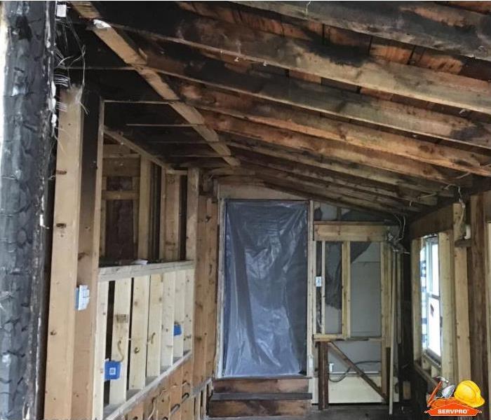 Burnt stud wall and framing is pictured in a house that experienced a fire.