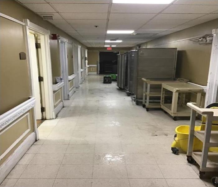wet floors in hallway of business. Equipment being placed to dry floors