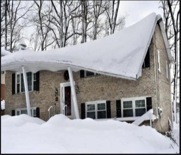 over 2 feet of snow on roof of home causes the roof to buckle