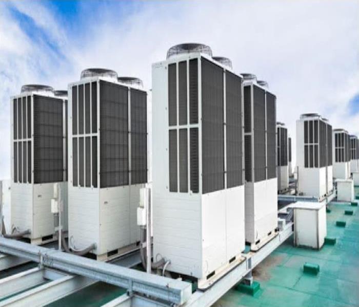 rows of commercial HVAC system on building roof